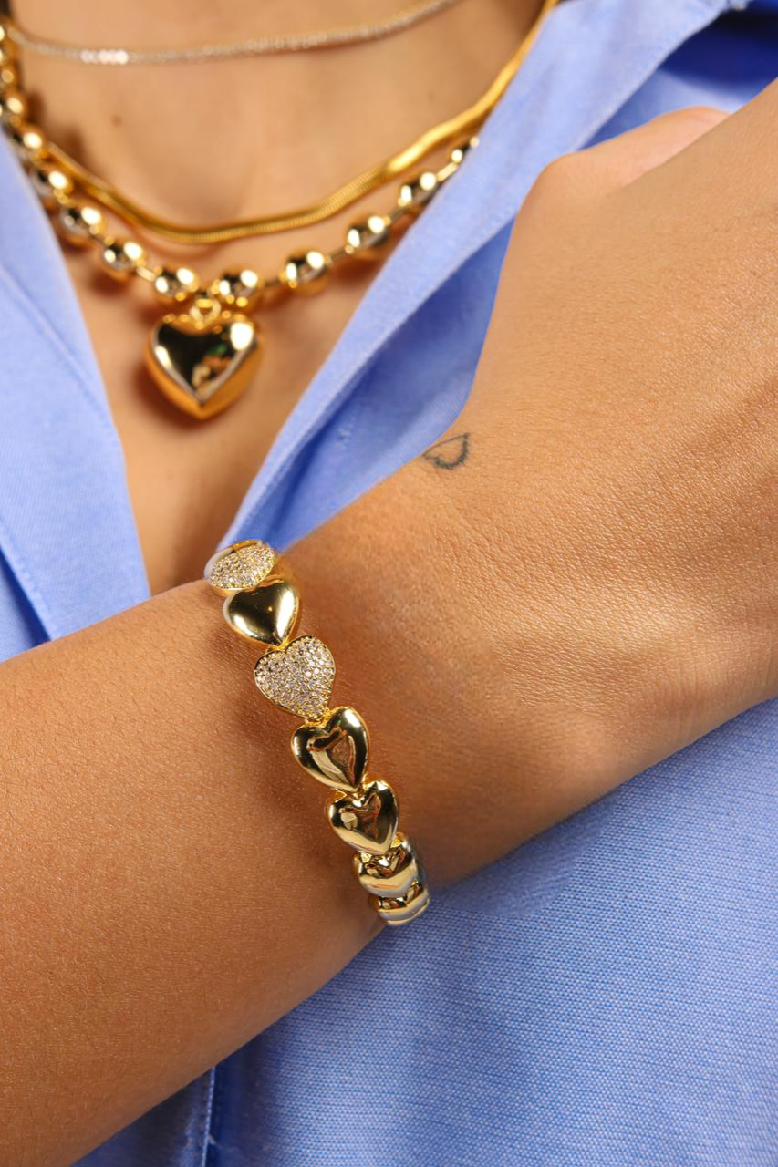 Pulsera estilo bangle de corazones lisos y en pave intercalados bañada en Oro