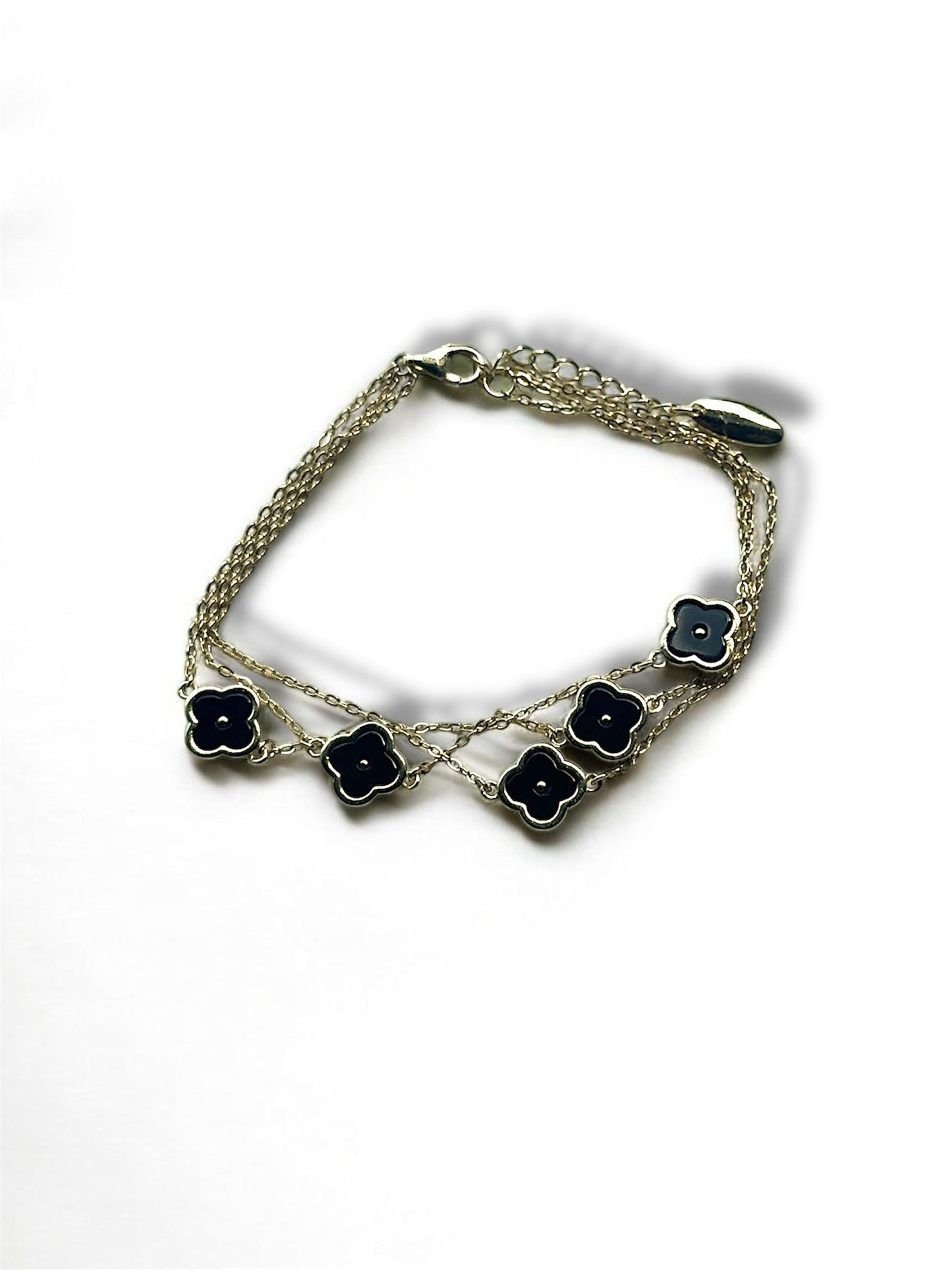 Pulsera de plata bañada en oro amarillo con dijes en forma de trébol de ónix