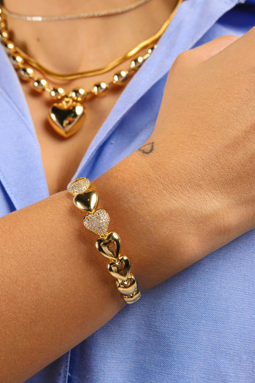 Pulsera estilo bangle de corazones lisos y en pave intercalados bañada en oro